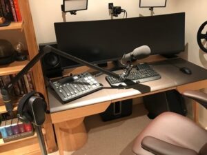 Kompaktes Mikrofon am Schwenkarm auf einem Schreibtisch mit Audiotechnik