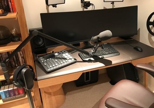 Kompaktes Mikrofon am Schwenkarm auf einem Schreibtisch mit Audiotechnik