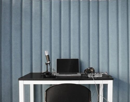 Homeoffice-Schreibtisch mit Laptop, Mikrofon und Akustikabsorbern